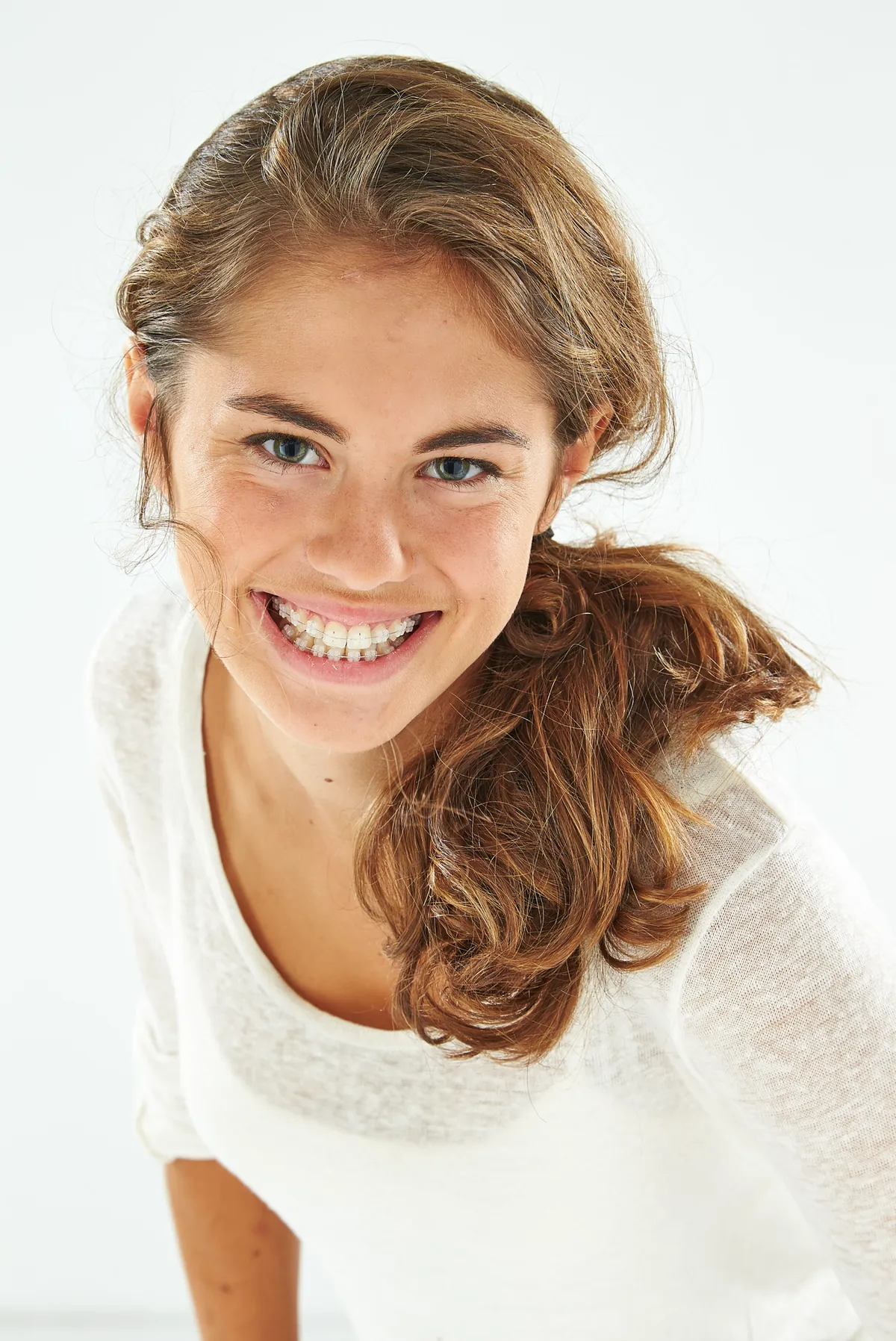 Adolescente souriante avec bagues céramiques translucides